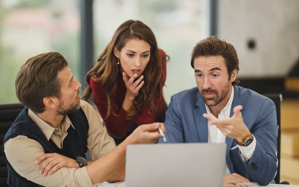 Three colleagues working together on a laptop